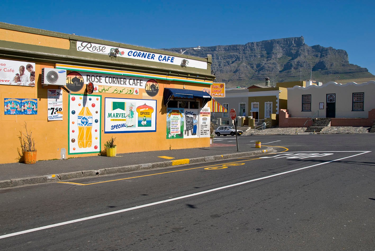 Rose Corner Cafe Cape Town South Africa - October 13th, 2007: Colorful Rose Corner Cafe in the Malay Quarter of Cape Town. This traditional colorful african architecture can still be found between the new buildings of modern Cape Town. In the background the Table Mountain can be seen.