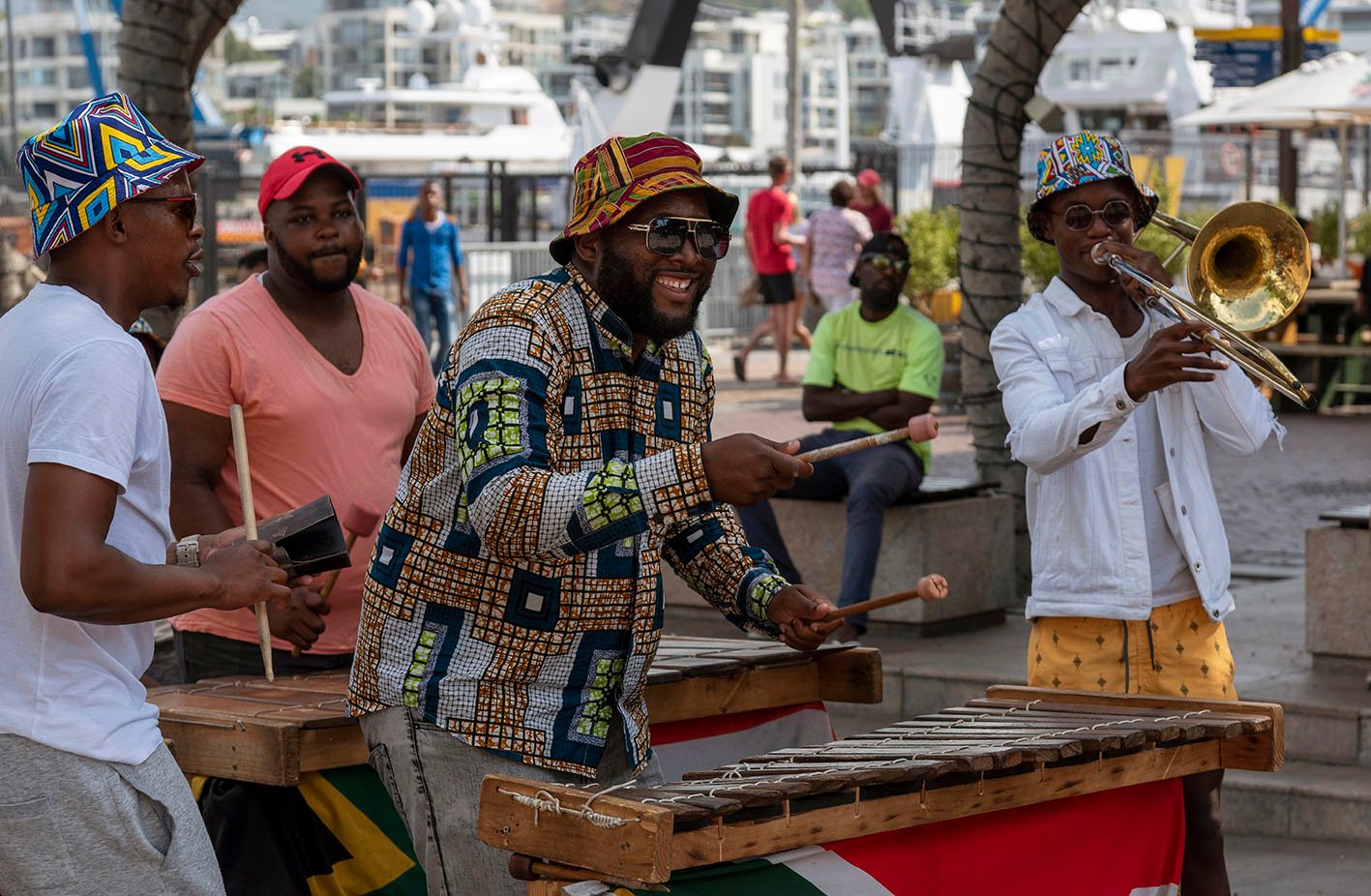 Street-musicians-waterfront-capetown Cape Town, South Africa. December 2019. Street musician in colourful clothing plays xylophone on the waterfront area of central Cape Town.