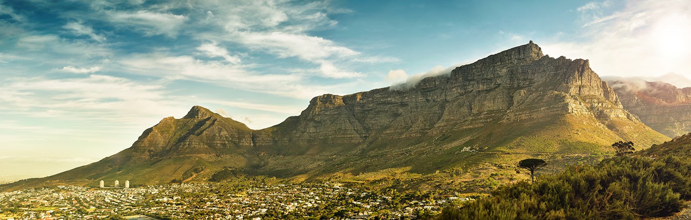 High resolution panorama of the iconic world wonder, table mountain Breathtaking landscape panorama of table mountain, in cape town, south africa, with dramatic clouds and warm sunlight casting a shadow from the mountain over the city.